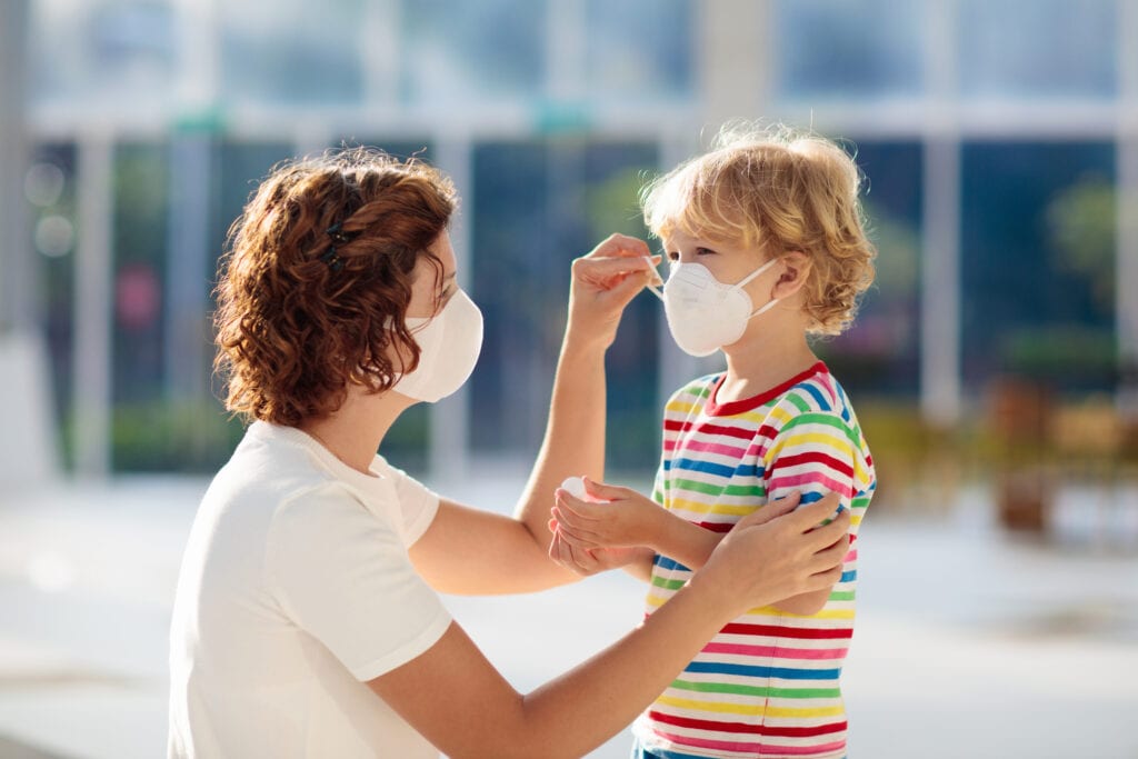 Mother putting on a face mask for her child