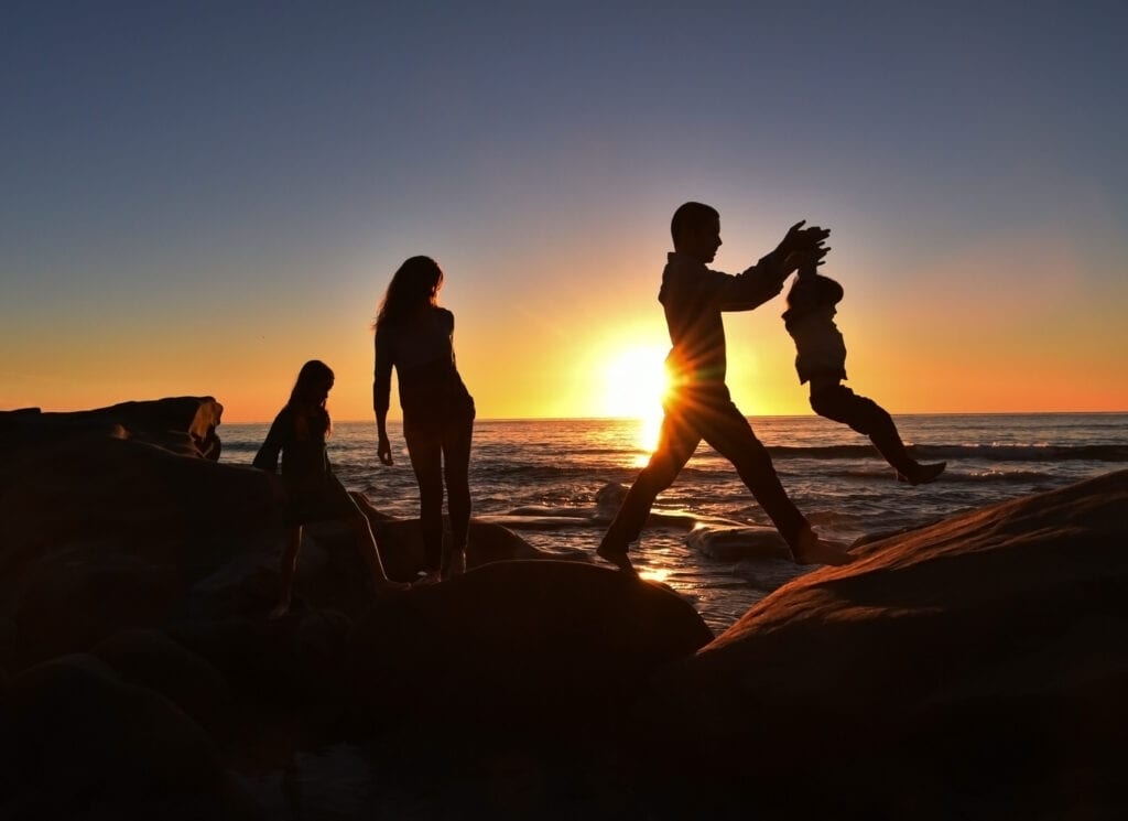 Silhouette of a family playing at a beach